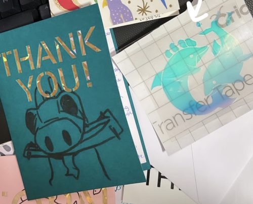 Green thank you card featuring a dragon on the left, holographic iron-on of two dolphins on the right